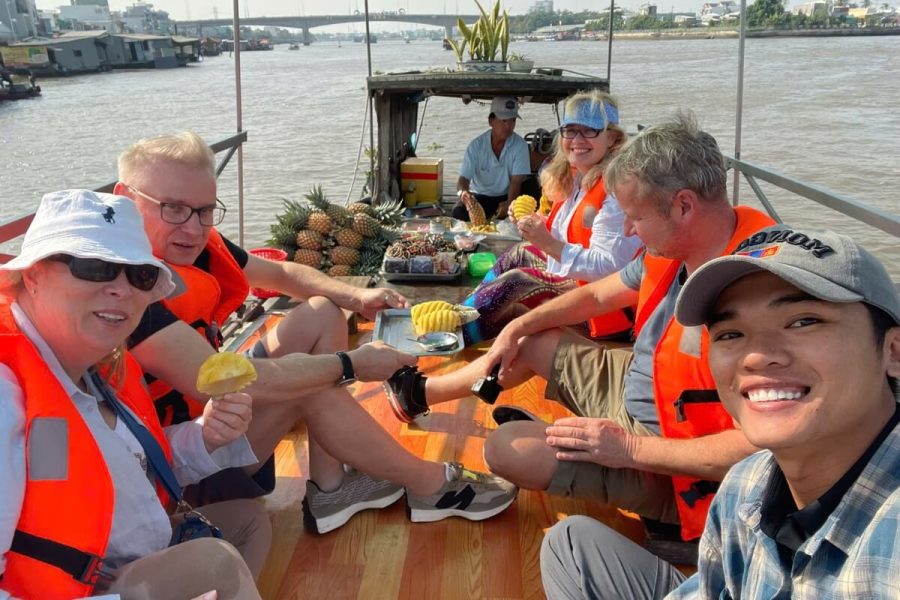 eating fruit in a boat in Mekong Delta Tour - Vietnam Vacation Packages 19 Days